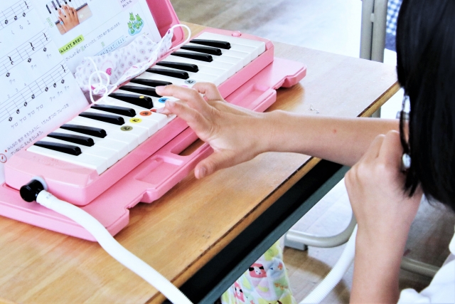 鍵盤ハーモニカを吹く子供